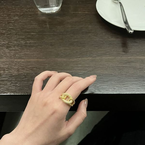 Широкое золотистое кольцо с прорезным логотипом и фианитами CJL40848