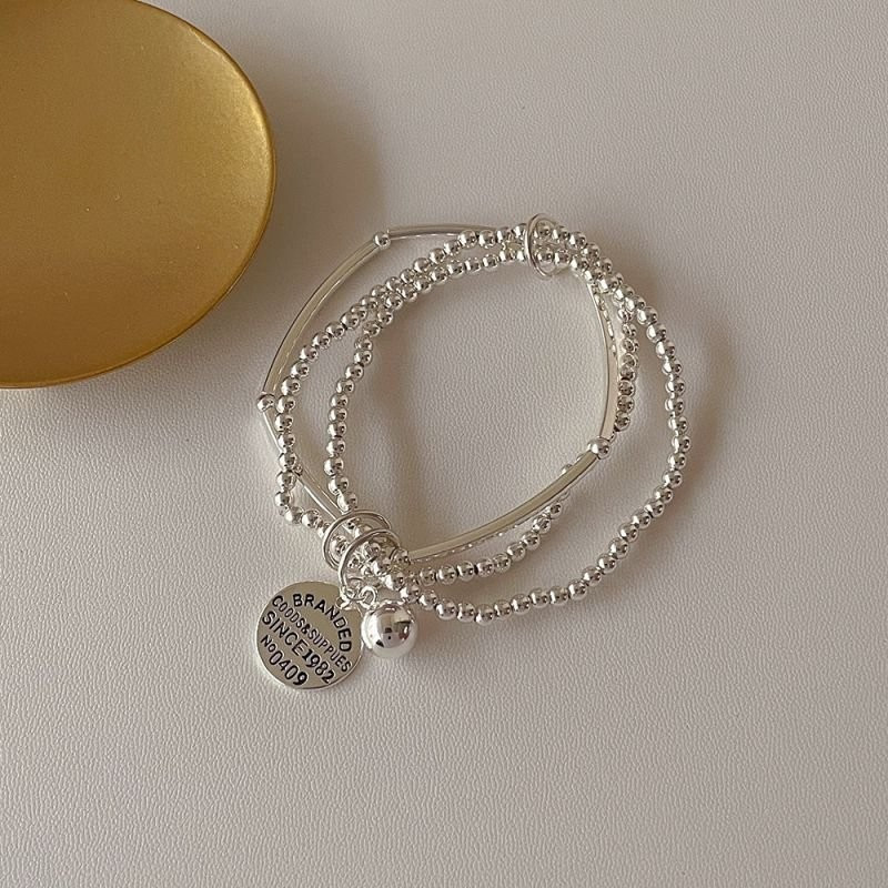 Многослойный браслет из серебристых бусин с жетоном CJE02756