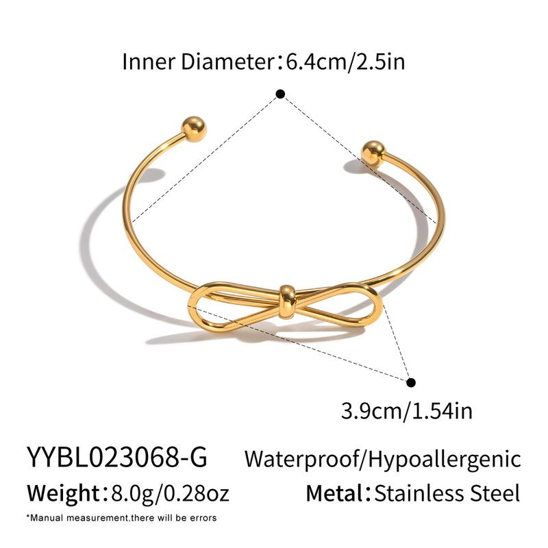 Золотистый браслет-кафф с центральным элементом в виде банта 1J12459CJJ
