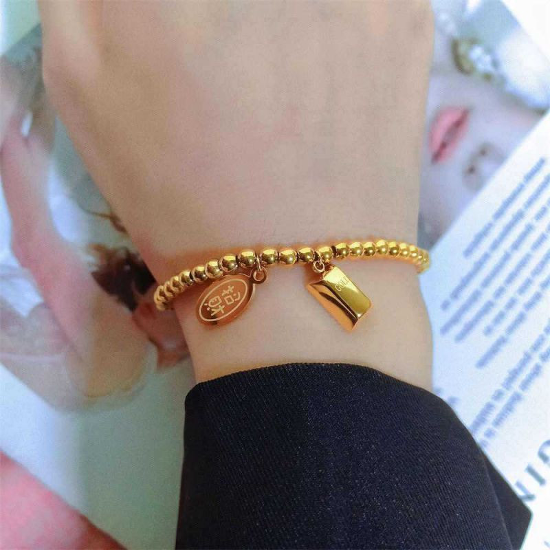 Браслет-цепочка из золотистых бусин с гравированными подвесками CJL11342