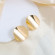 Золотистые серьги с изогнутым диском CJX86735 Золотистые серьги с изогнутым диском CJX86735