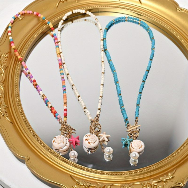 Бусы из мелкого бирюзового камня с подвеской-монетой CJP74984