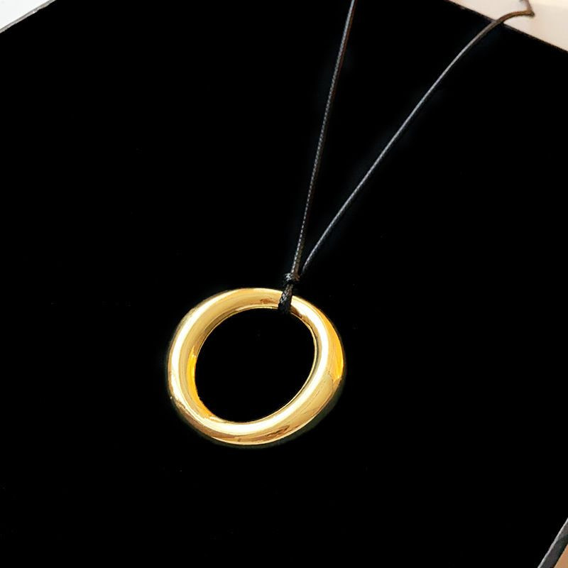 Массивное золотистое кольцо на тонком шнурке CJH12100